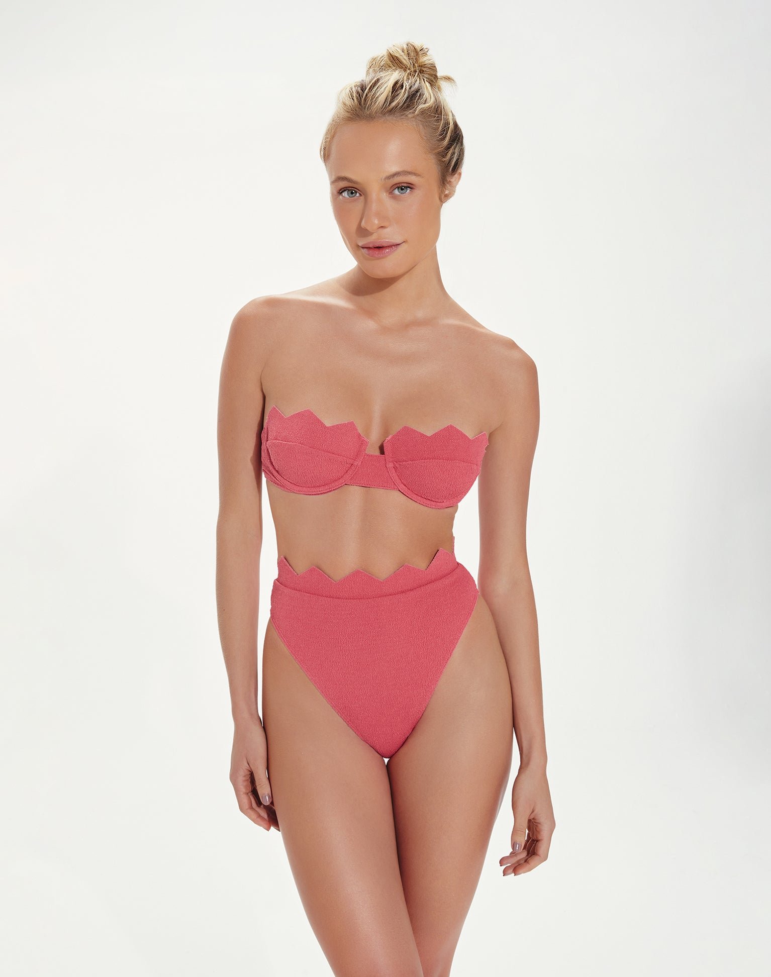 Model in the Firenze Imani Bandeau Top and Hot Pant Bottom, a pink textured bikini with zigzag edges and a high waist
