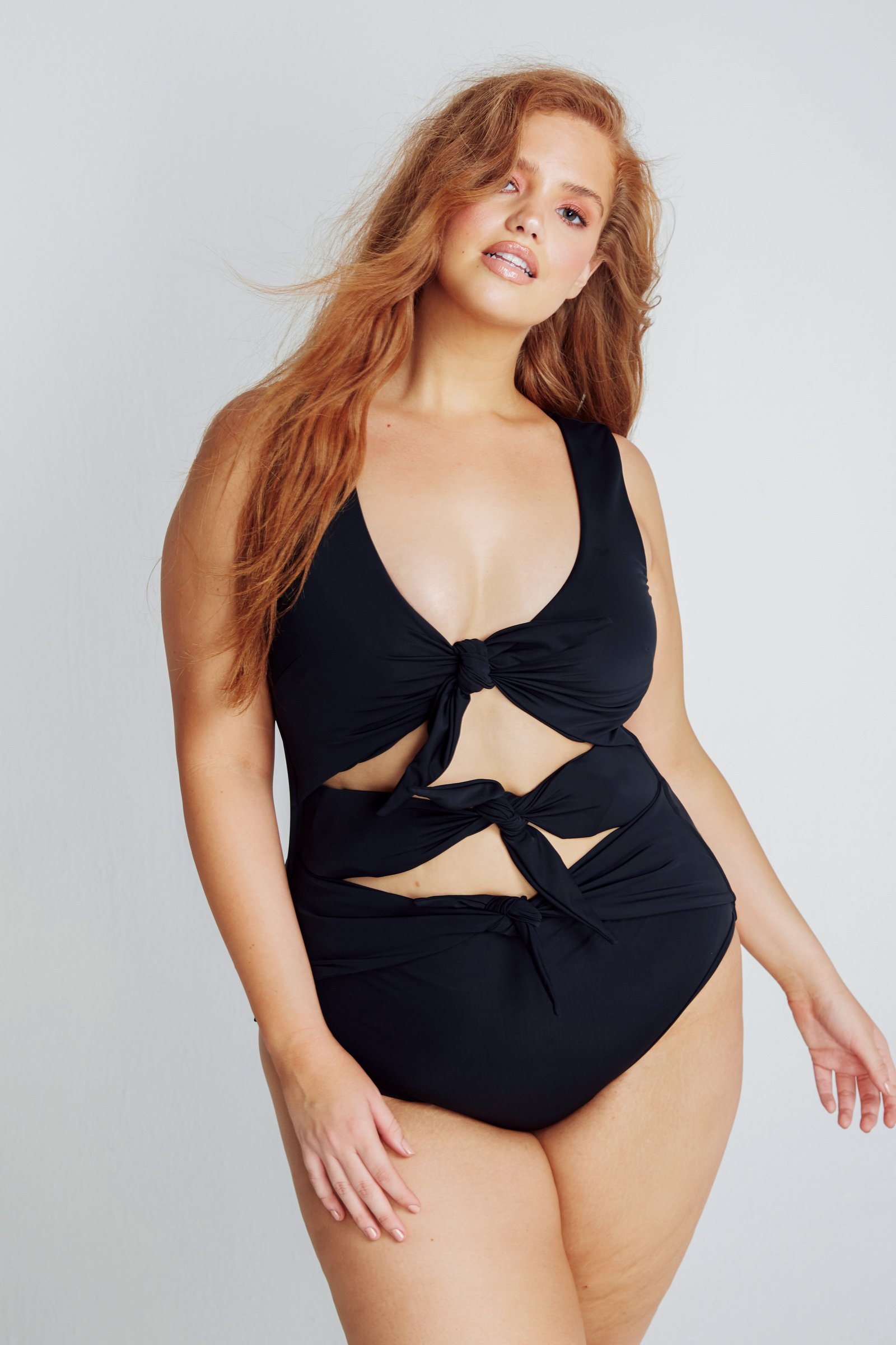Model in the black Goddess one-piece by Alpine Butterfly Swim, with three knotted cutouts down the front