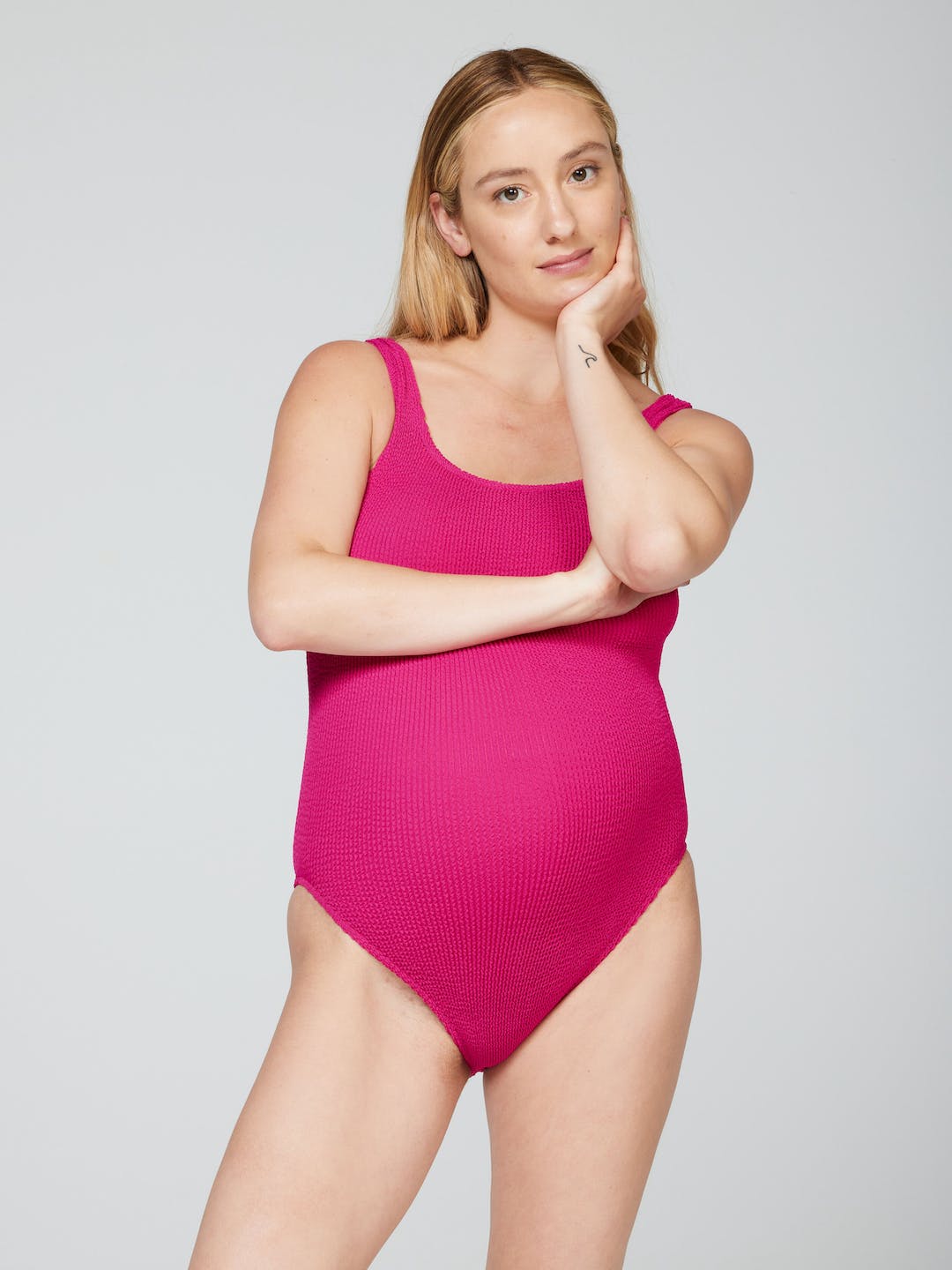 Pregnant model in the Aplomb One-piece in magenta crinkle fabric, scoop neck and wide straps, front view