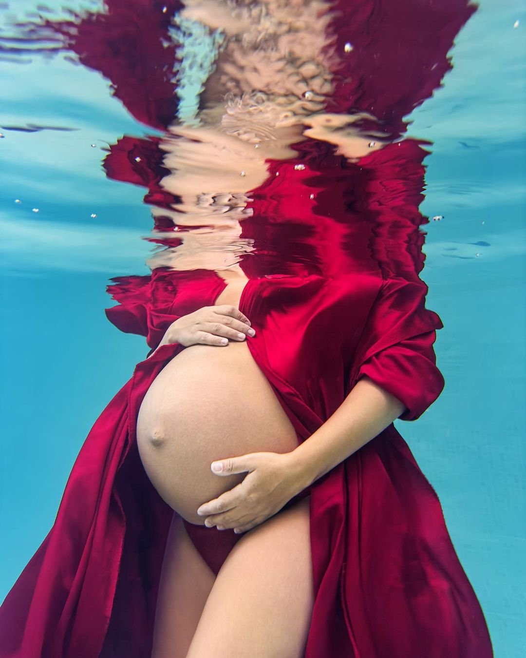 Cover Image of a pregnant woman underwater with a red dress
