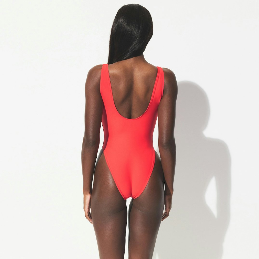 Back of the Plunge One Piece in bright red, with a low scoop back and high-cut legs