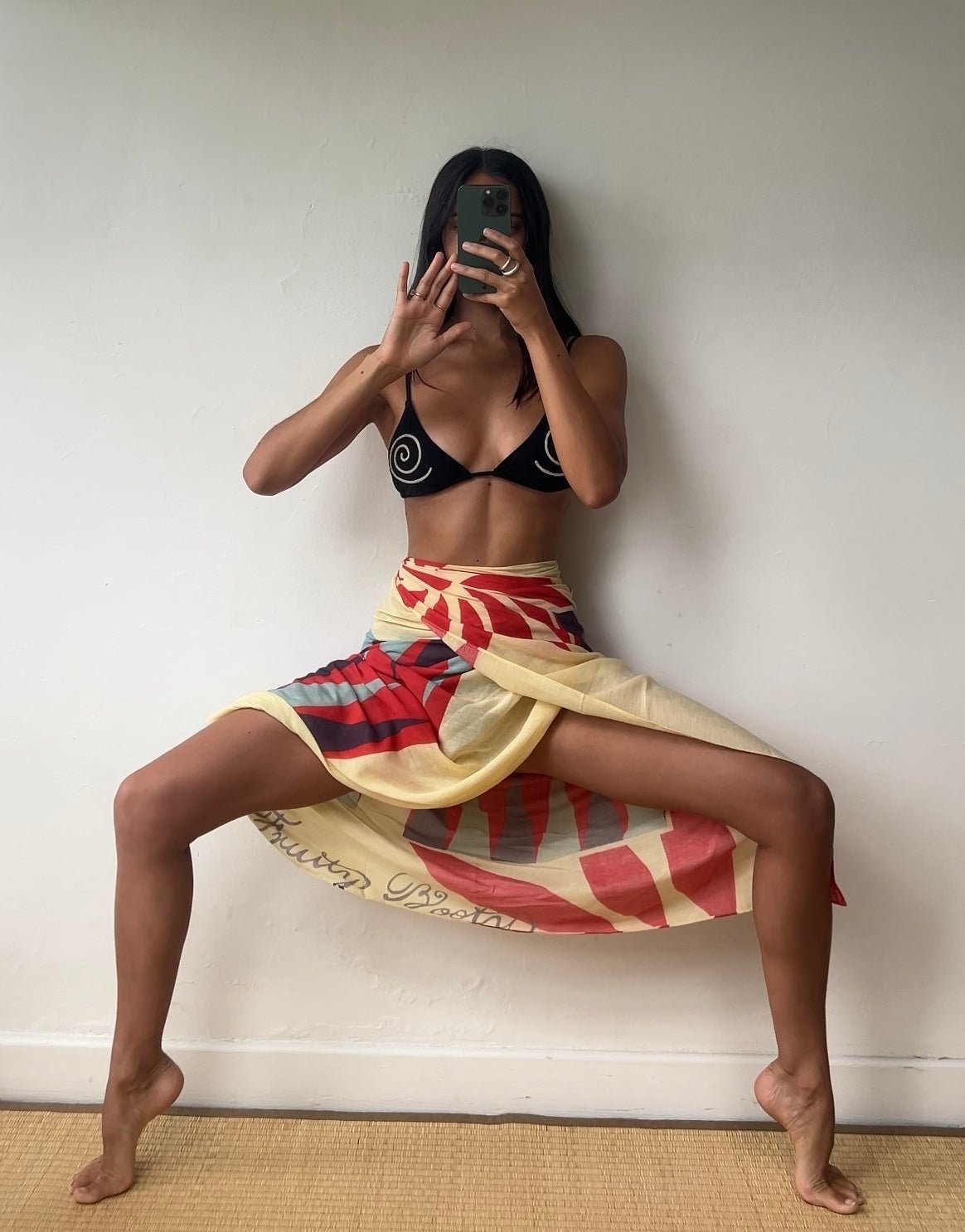 Mirror selfie in a black swirl-print bikini top and the Backgammon Sarong, a cream, red and blue printed wrap