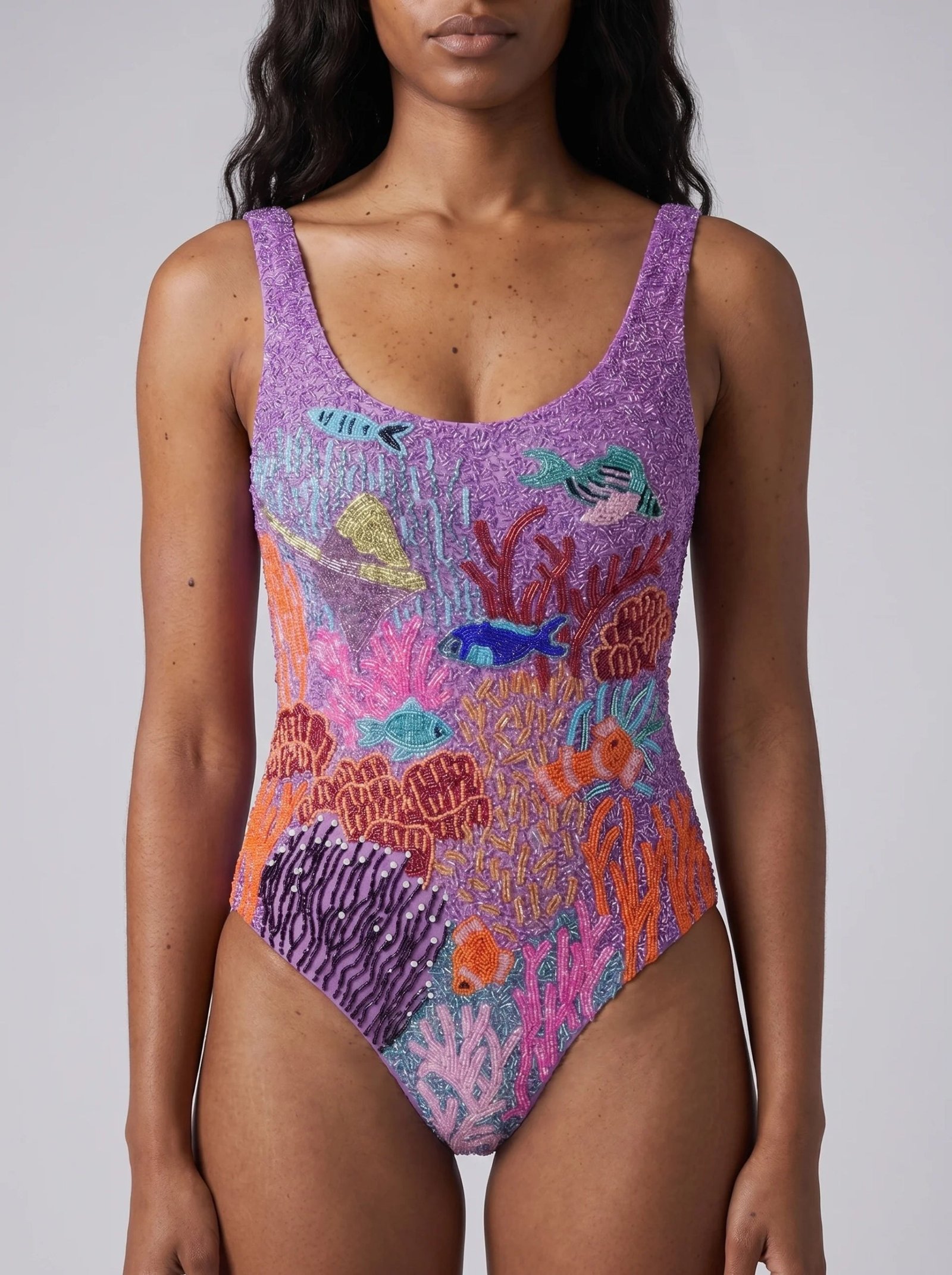 Oceanus lilac one-piece showing dense hand-beaded fish and coral embellishment in a studio close-up